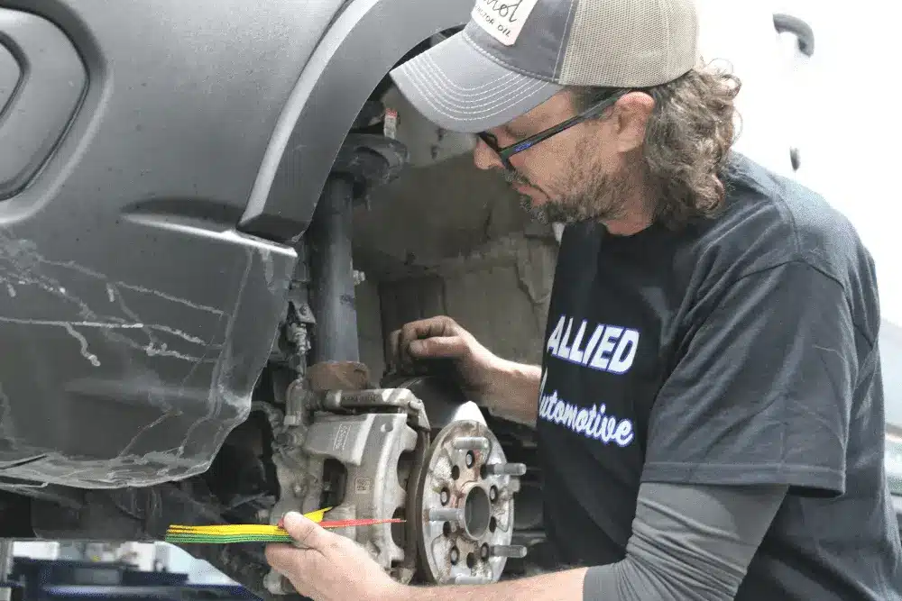 winter car maintenance, auto repair in Allentown, PA at Allied Automotive. Auto technician at Allied Automotive working on a vehicle's brake system.