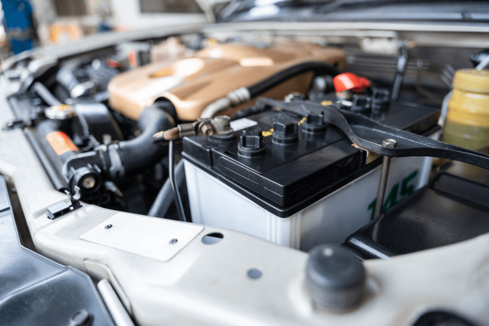 car battery replacement, auto repair in Allentown, PA at Allied Automotive. Car battery in engine bay of a vehicle, showing clean terminals, secured connections, and nearby components.