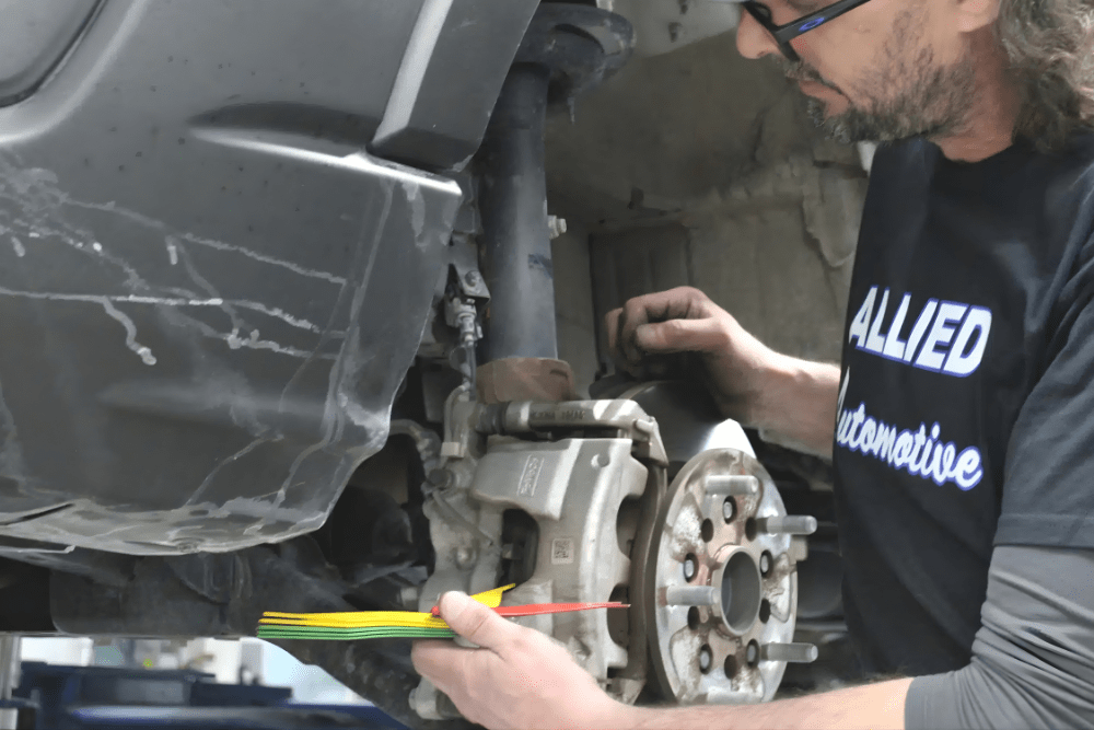 Brake inspection, auto repair in Allentown, PA. Image of a technician inspecting a vehicle’s brake assembly, highlighting expert service to ensure durability, safety, and reliable performance.