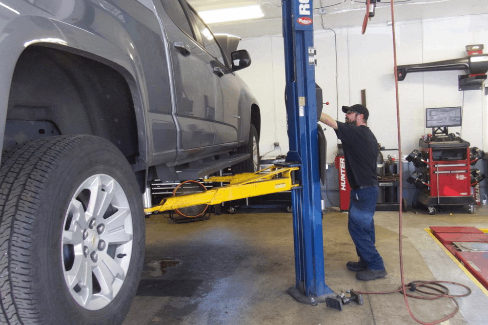 Auto repair in Allentown, PA by Allied Automotive. Image of a technician lifting a pickup truck on a two-post lift inside a professional shop, highlighting routine maintenance, inspections, and dependable full-service vehicle repairs.