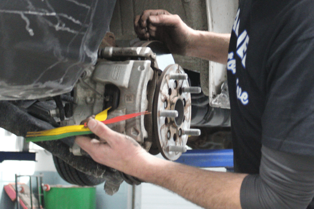 Brake Repair in Allentown PA At Allied Automotive. Image of Mechanic measuring brake pad thickness with inspection gauge