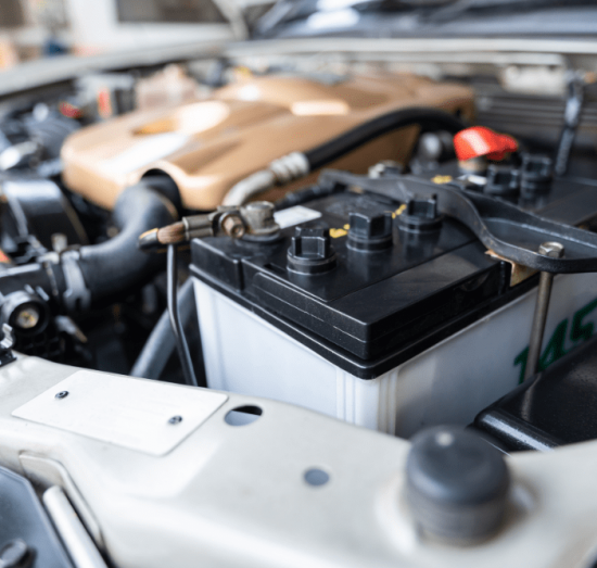 car battery replacement, auto repair in Allentown, PA at Allied Automotive. Car battery in engine bay of a vehicle, showing clean terminals, secured connections, and nearby components.