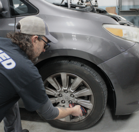 Honda or Toyota Service in Allentown, PA At Allied Automotive. Mechanic servicing the front wheel of a grey Toyota
